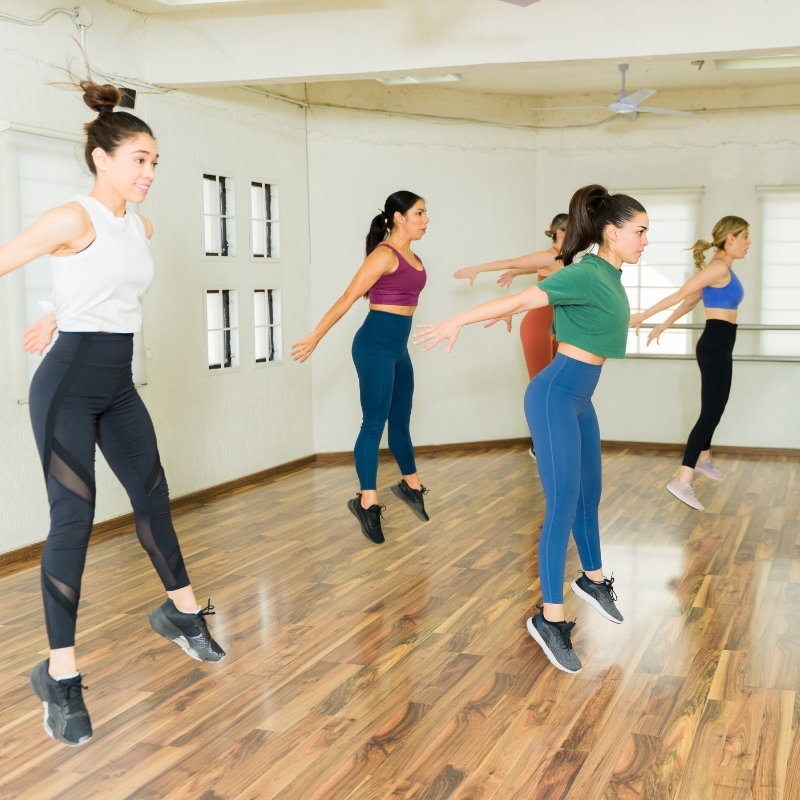 mulheres saltando numa aula coletiva com HIIT